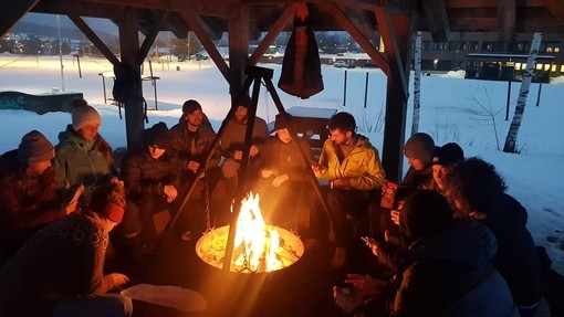 Group of students socialising by a fire in the outdoors in Norway 